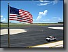 The American flag is proudly flown over the terminal building.  Note the new surface on the aircraft parking area.